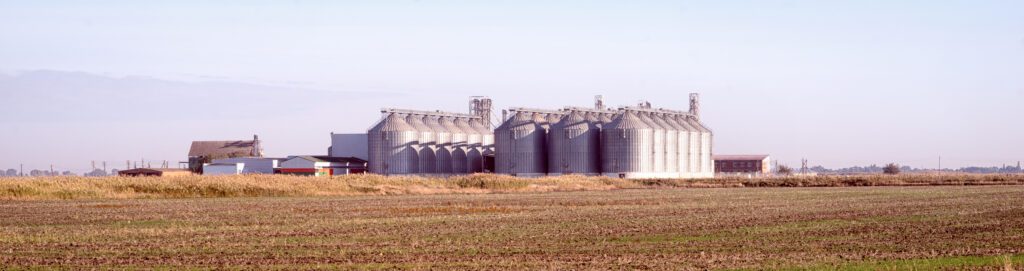 grain elevator buildings in the field. agriculture panoramic landscape.