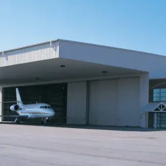 A White Color Warehouse With an Airplane at Front