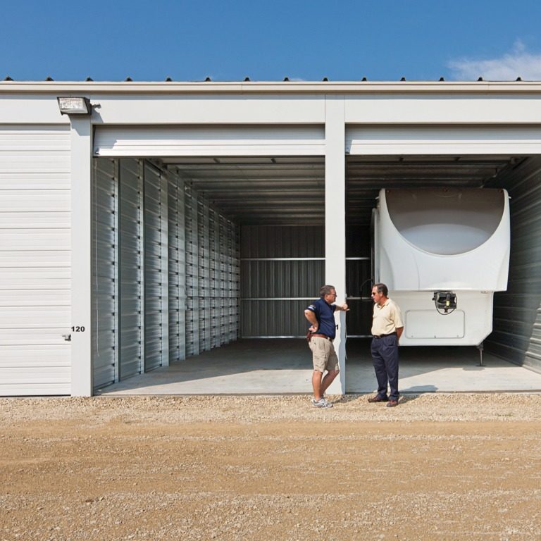 Two older men standing in front of a self storage